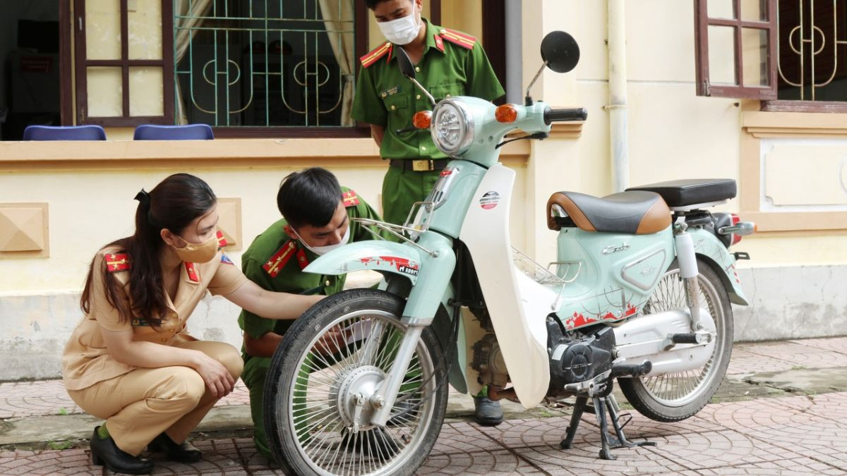 Cán bộ công an đang tiến hành kiểm tra số khung, số máy của xe để xác minh thông tin, đảm bảo tính chính xác cho việc cấp biển số xe 18.