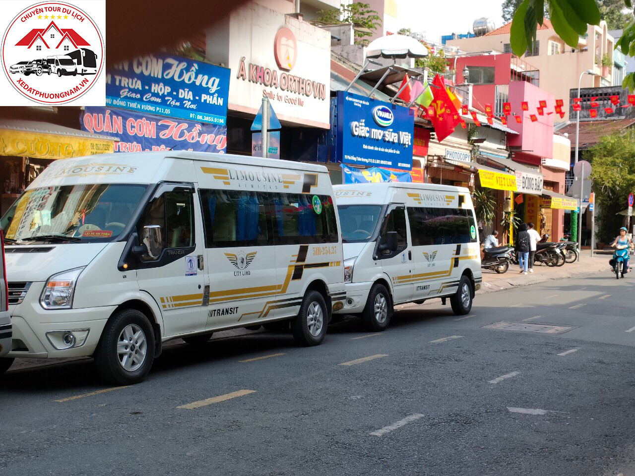 Chiếc Ford Transit 16 chỗ màu bạc đang di chuyển, một lựa chọn phổ biến cho các dịch vụ thuê xe 16 chỗ