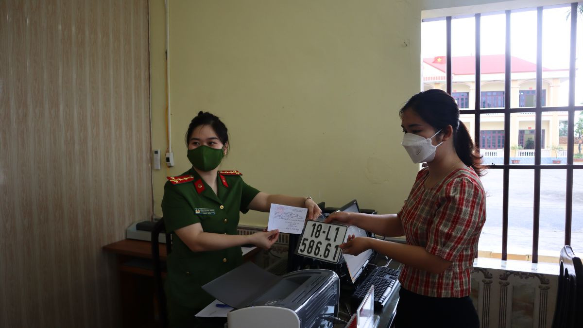 Chủ xe vui mừng nhận giấy đăng ký và biển số xe 18 mới, đánh dấu hoàn tất quá trình hợp pháp hóa phương tiện giao thông.