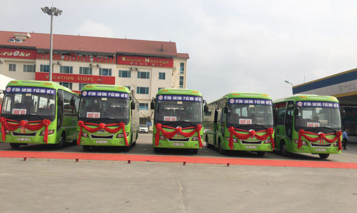 Xe buýt 212 hiện đại màu xanh đang chạy trên đường, phục vụ tuyến Hà Nội Bắc Ninh